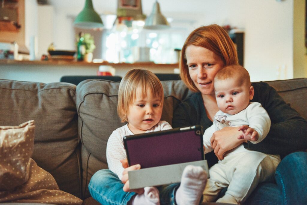 Mum with children and laptop copyright free image by Alexander Dummer on Unsplash